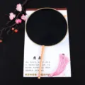 Black traditional Chinese round fan with wooden handle and delicate pink tassel detail. - Beech Wood Handle Black