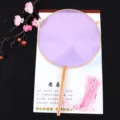 Vue détaillée de l'éventail rond chinois traditionnel en tissu violet avec pompon rose. - Manche en Bois de Hêtre Violet / Violet