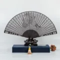 Abanico plegable de sándalo negro con diseño tallado hueco, regalo de estilo chino. - Ébano Flores Voladoras