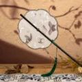 Éventail à main chinois traditionnel avec motif papillon, long manche noir et pompon vert. - Nouveauté - Éventail à huit pétales aux papillons printaniers