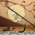 Éventail rond traditionnel chinois long manche motif fleur de prunier jaune avec gland. - Nouveauté - Éventail à huit pétales motif prunier et bambou