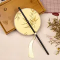 Traditionele Chinese ronde waaier met zwarte handgreep en gouden bamboeblad motief. - 35cm Lengte / Ronde Gele Bamboe Bladeren