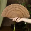 Natural green sandalwood folding fan with elegant tassel, Chinese style Hanfu decor. - Xianzi Relief Green Sandalwood