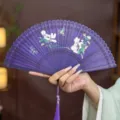 Handheld purple Chinese folding fan with hollow carved bamboo and floral painting for dance. - Purple Fluttering Butterfly