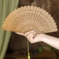 Elegant wooden folding fan with delicate hollowed-out carvings and tassel for Hanfu style. - Bamboo Shadow Relief Green Sandalwood