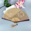 Traditional Chinese sandalwood folding fan with intricate hollow carved design and tassel. - Dragon and Phoenix / 7 Inch (23cm)