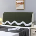 Detail view of dark green plush headboard cover featuring a chic white ruffled scalloped edge. - Dreamy Green