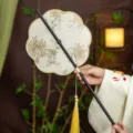 Traditional Chinese Hanfu silk fan with floral embroidery, yellow tassel, and bamboo handle. - 8-Petal Graceful Waist Fan (Bamboo Edge)