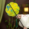 Traditional Chinese folding waist fan with landscape painting, green tassel and black handle. - 8-Petal Crane Dancing Landscape Waist Fan (Bamboo Edge)