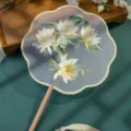 Traditional Chinese embroidery round fan with long wooden handle and tassel decoration. - Double-Sided Embroidered Eight-Petal Fan "Epiphyllum" with Beechwood Handle