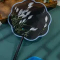 Traditional Chinese embroidered round fan with black handle, blue tassel and reed design. - Double-Sided Embroidered 8-Petal Fan - Reeds & Moonlight (Beechwood Handle)
