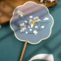 Chinese style embroidered round fan with wooden handle and white tassel, greyish blue floral variant. - Double-Sided Embroidered 8-Petal Fan - Flower Fairy (Beechwood Handle)