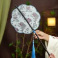 Traditional Chinese Hanfu round fan, blue floral brocade, black bamboo handle, tassel. - 8-Petal Fish Jumping Over Waves Waist Fan (Bamboo Edge)