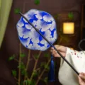 Traditional Chinese style ginkgo pattern folding fan with blue tassel, bamboo handle for Hanfu. - Lily Nanzhen Waist Fan (Bamboo Edge)