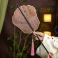Traditional Chinese Hanfu folding fan with bamboo handle and elegant pink tassel decoration. - Phoenix Crown Colorful Feathers Waist Fan (Bamboo Edge)