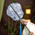 Traditional Chinese bamboo waist fan with elegant blue floral fabric and tassel charm for Hanfu. - Phoenix Crown Morning Dew Waist Fan (Bamboo Edge)