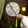 Traditional Chinese round fan with elegant embroidery and golden tassel, perfect for Hanfu. - Round Flower Butterfly Waist Fan (Bamboo Edge)