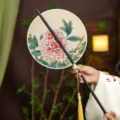 Chinese traditional hand fan with elegant peony flower print, bamboo handle and golden tassel. - Round Blooming Peony Waist Fan (Bamboo Edge)