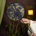 Traditional Chinese embroidered round fan with gold bamboo pattern and black tassel for Hanfu. - Round Golden Plum Blossom and Bamboo Waist Fan (Bamboo Edge)