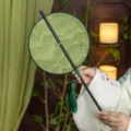 Traditional Chinese style round Hanfu fan with green bamboo handle and tassel decoration. - Round Green Mountains Waist Fan (Bamboo Edge)