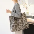 Modieuze canvas draagtas met luipaardprint gedragen door een model in een minimalistische setting - Crèmegeel