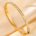 Gold titanium steel bangle close-up, featuring sparkling crystal stones and sleek white inlay. - DQ-2446-1