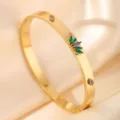 Close-up detail of a gold stainless steel bracelet with green and purple marquise cubic zirconia. - DQ-2441-4