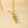 Detailed view of a delicate gold seahorse pendant necklace on textured fabric background. - Seahorse