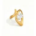 Close-up detail shot of a modern asymmetrical gold ring featuring an elegant oval white zircon. - White Oval