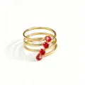 Detailed close-up of a multi-layer gold ring featuring sparkling red zircon stones elegance. - Red Multi-layer