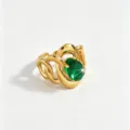 Close-up detail of the luxury stainless steel gold ring featuring an elegant green zircon stone. - Green Intertwined