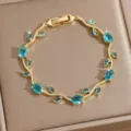 Close-up of luxury gold-plated vine bracelet featuring sparkling blue zirconia leaf stones. - DQ-W-4092-3