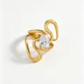 Detailed close-up of a stylish gold-plated swirl stainless steel ring with a sparkling oval zircon centerpiece. - Open Adjustable / White