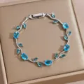 Silver-tone vine tennis bracelet featuring sparkling blue cubic zirconia leaf charms. - DQ-W-4094-5