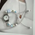 Vista dettagliata di un orologio braccialetto di perle con ciondolo a fiore sorridente. - Perline Cubo di Zucchero Blu (Quadrante Bianco)