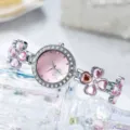 Detailansicht der silbernen Armbanduhr mit rosa Herz-Kleeblättern und Kristallen - Rosa