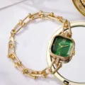 Nahaufnahme der eleganten goldenen Damenuhr mit smaragdgrünem quadratischem Zifferblatt - Grünes Zifferblatt Goldgehäuse