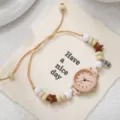 Detailed view of women's quartz watch featuring colorful beads and woven drawstring strap - Arabic Numerals Cream