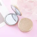 Detailed view of the portable double-sided folding makeup mirror with glamorous gold glitter finish. - Rose Gold