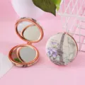 Detailed view of portable double-sided compact pocket makeup mirror with vintage Eiffel tower print. - Blue Purple Flower