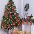 Primer plano de lazos de satén rojo y cadenas de perlas que decoran un árbol de Navidad. - Color/tamaño/estilo personalizado