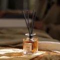 Duftdiffusor mit Rattan-Stäbchen und bernsteinfarbener Flüssigkeit für ein optimales Raumklima. - Oud Holz