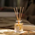 Klassische Duftstäbchen Glasflasche mit gelbem Duftöl und natürlichen Rattanstäben. - Osmanthus