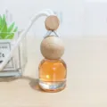 Auto Hängeparfüm Flasche mit Holzdeckel und orangefarbener Flüssigkeit für Lufterfrischer - Kölnisch Wasser
