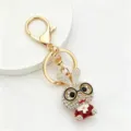 Primo piano portachiavi coniglio strass, ciondolo borsa carino in metallo dorato cartone animato. - Rosso bianco