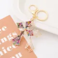 Close-up of sparkling rhinestone cross keychain, showing fine metal craftsmanship and crystals. - Cross Style 23