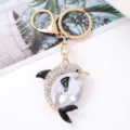 Close-up detail of the sparkling rhinestone dolphin keychain with gold metal hardware and hook. - Dolphin 7
