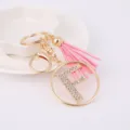 Detail view of the sparkly rhinestone letter F charm with soft pink tassel keychain. - Letter F