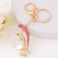 Detailed view of the cute golden dolphin keychain with pink rhinestones and a white pearl bead. - Dolphin 14