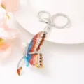 Vue détaillée du porte-clés en métal papillon exquis avec émail coloré, strass et perle. - Collier Papillon Bleu Étincelant Style 13